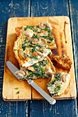 Frittata with mushrooms, spinach and ham on a chopping board