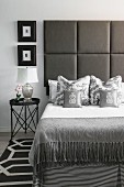 Elegantes Schlafzimmer in Grautönen, gepolstertes Betthaupt
