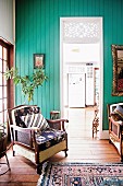 Old armchair in front of turquoise painted wall with passage