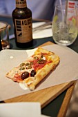A slice of pizza on paper at a trendy eatery in Hamburg, Germany