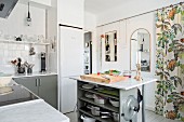 Kücheninsel mit offenem Regal und Marmorplatte in skandinavischer Küche mit Vorhang
