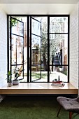 Fensterbank mit Zimmerpflanzen und Bücherstapel