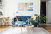 Blaues Retro Sofa, Stehleuchte und Beistelltischchen im Wohnzimmer
