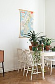 White wooden chairs around potted house plants on dining table in retro interior