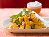 A spicy mango salad with sheep's cheese, basil and chives