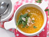 Carrot and potato cream soup with rocket and almond flakes