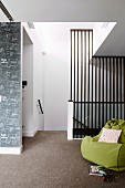 Green beanbag in a modern hallway with gray carpeting