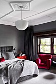 Elegant bedroom in shades of gray with red accents