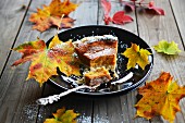Herbstkuchen aus Süsskartoffeln, mit Herbstblättern dekoriert, auf Teller mit Kuchengabel