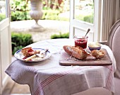 Gedeckter Tisch mit Brot, Marmelade und Clotted Cream