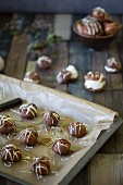 Chocolate profiteroles on a baking tray