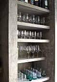 Neatly arranged glasses on concrete shelves