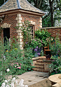 Garden house with climbing rose, vine, iris