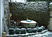 Brunnen im Winter mit Holzbrett abgedeckt