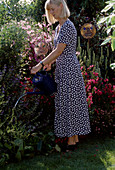 Woman watering the perennial bed