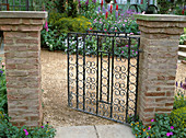 Wrought iron garden gate with brick posts