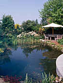 Pond with sitting area and white umbrella