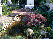 Terrasse mit Teich in kleinem Garten