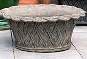 Pot made of coloured cement with wickerwork pattern