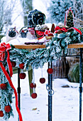 Table with advent decoration, fir branch garland, lantern and apples