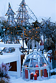 Balcony seating area, mini greenhouse with candles, illuminated ornamental fir trees in the snow