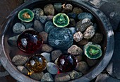 Bowl with stones, coloured glass balls and frogs as floating candles