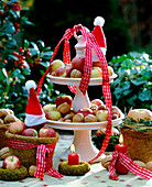 Porcelain tagere with walnuts, ornamental apples, coco pots, moss rings, Father Christmas cap