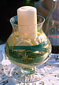 Windlicht im Glas mit Wasser, Zitronen und Miscanthus (Chinaschilfblätter)