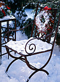 Snowy iron chair with berry wreath