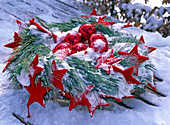 Wreath made of Pinus (silk pine) with red stars and balls