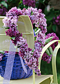 Syringa vulgaris / Herz aus Fliederblüten an Stuhllehne gehängt