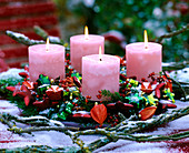 Adventsgesteck mit Zweigen und rosa Kerzen