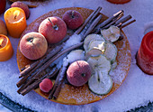 Tellerdeko mit gefrorenen Äpfeln, Apfelscheiben und Zimtstange