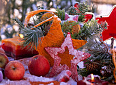 Star-shaped sisal bag filled with fir branches, malus (apples), citrus (oranges)
