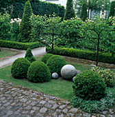 Pears (Pyrus communis) as espalier fruit, Buxus (box) topiary Balls and hedges as edging, stone balls as decoration