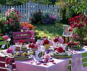 Gedeckter Tisch mit Rosenblüten, Lavendel und Obst