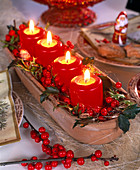 Ungewöhnlicher Adventskranz mit roten Kerzen und Ilex