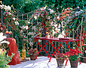 Balcony railing decorated with clematis, rosehip branches (pink)