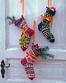 Door with Father Christmas decoration: colourful knitted socks with tree ornaments