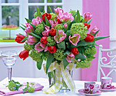 Bouquet of tulipa (tulip) and viburnum (snowball) in glass vase