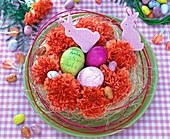 Easter basket with Dianthus flowers, Easter eggs, pink felt bunnies