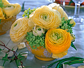 Strauß aus Ranunculus (Ranunkeln), Viburnum (Schneeball) in gelber Schale