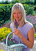 Woman with basket full of freshly cut lavandula (lavender)