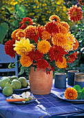 Strauß aus Dahlia (Dahlien in gelb, orange und rot) in oranger Vase