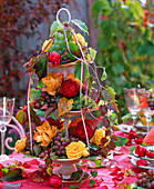 Autumn table decoration with roses and grapes