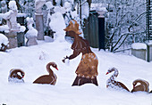 Iron figurine 'Farmer's wife feeding geese' in snowy