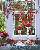 Rosa (Hagebutten, Rosen), Zweige im Fenster, Kerzenhalter aus Glas