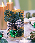 Branches of Abies (fir) with chequered ribbon on golden candle