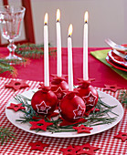 Advent wreath of red Christmas tree balls with star motifs and white candles