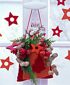 Rote Filztasche am Fenster gefüllt mit Schokoladennikoläusen, Chamaecyparis